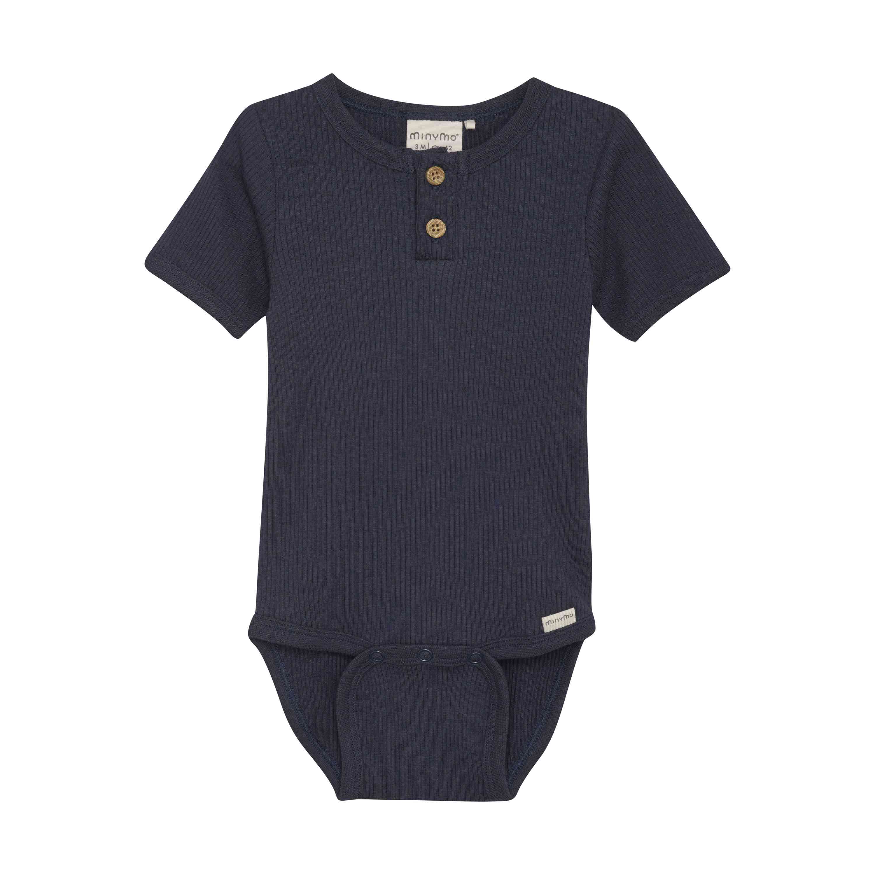 Ein marineblauer Babybody mit kurzen Ärmeln und gerippter Textur. Der Minymo - Body kurzarm aus Rippstoff hat zwei Holzknöpfe auf der Vorderseite, einen Druckknopfverschluss im Schritt und ein kleines weißes Etikett am unteren Rand.