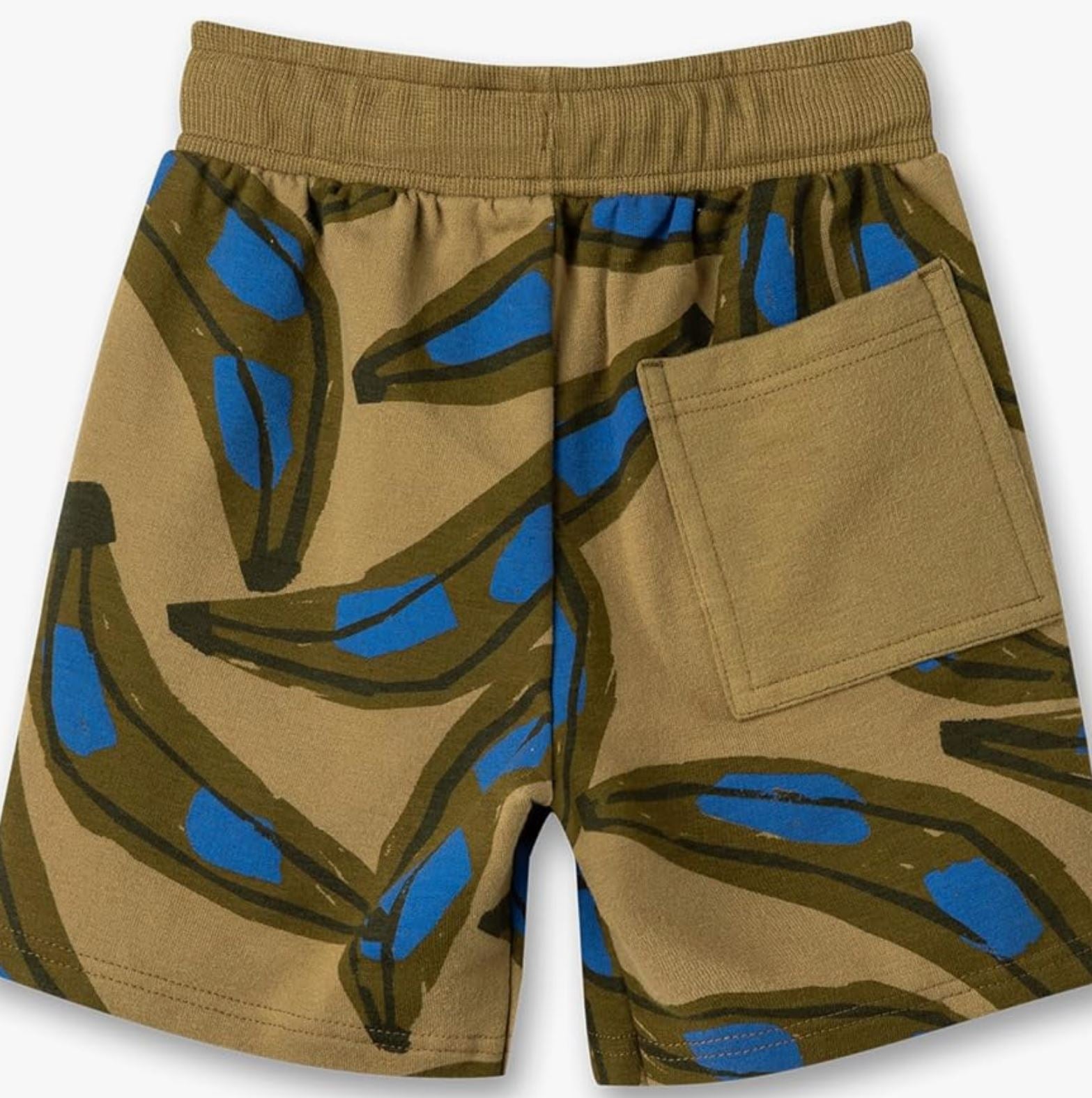 Ein Paar Sanetta - Hose Sweatshorts der Marke Sanetta hat einen elastischen Bund und einen hellbraunen Hintergrund mit einem abstrakten Bananenmuster in Grün- und Blautönen. Sie sind aus GOTS-zertifizierter Bio-Baumwolle gefertigt und haben außerdem eine einzelne Tasche auf der rechten Rückseite.