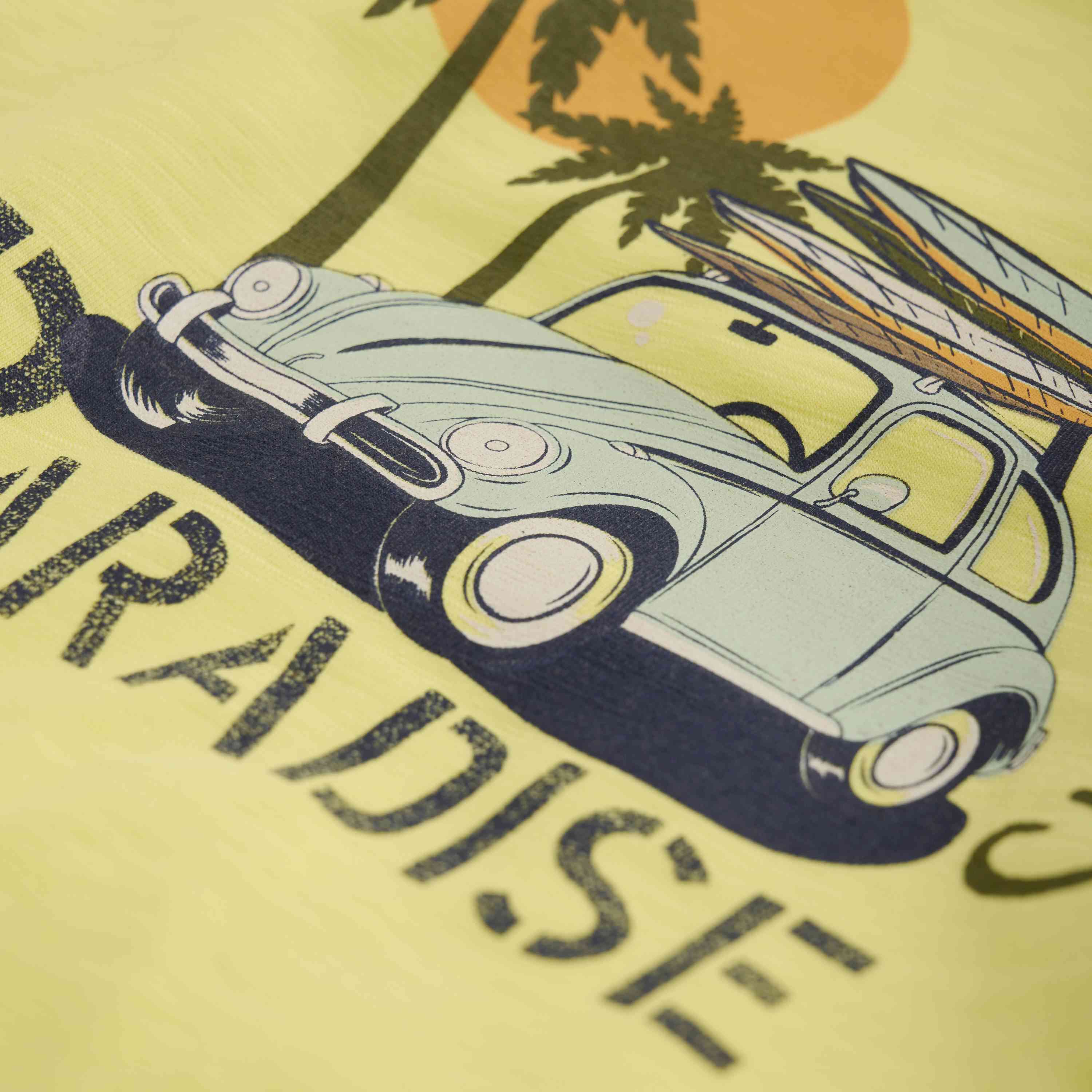 Illustration eines Oldtimers mit zwei Surfbrettern auf dem Dach, der bei Sonnenaufgang oder Sonnenuntergang unter Palmen geparkt ist. Das Wort „PARADISE“ ist teilweise unter dem Auto sichtbar, vor einem gelben Hintergrund. Dieses Kunstwerk weckt nostalgische Gefühle, ähnlich wie wenn man in Brimensdorf ein Geschäft entdeckt, das Minymo-T-Shirts von Minymo verkauft.