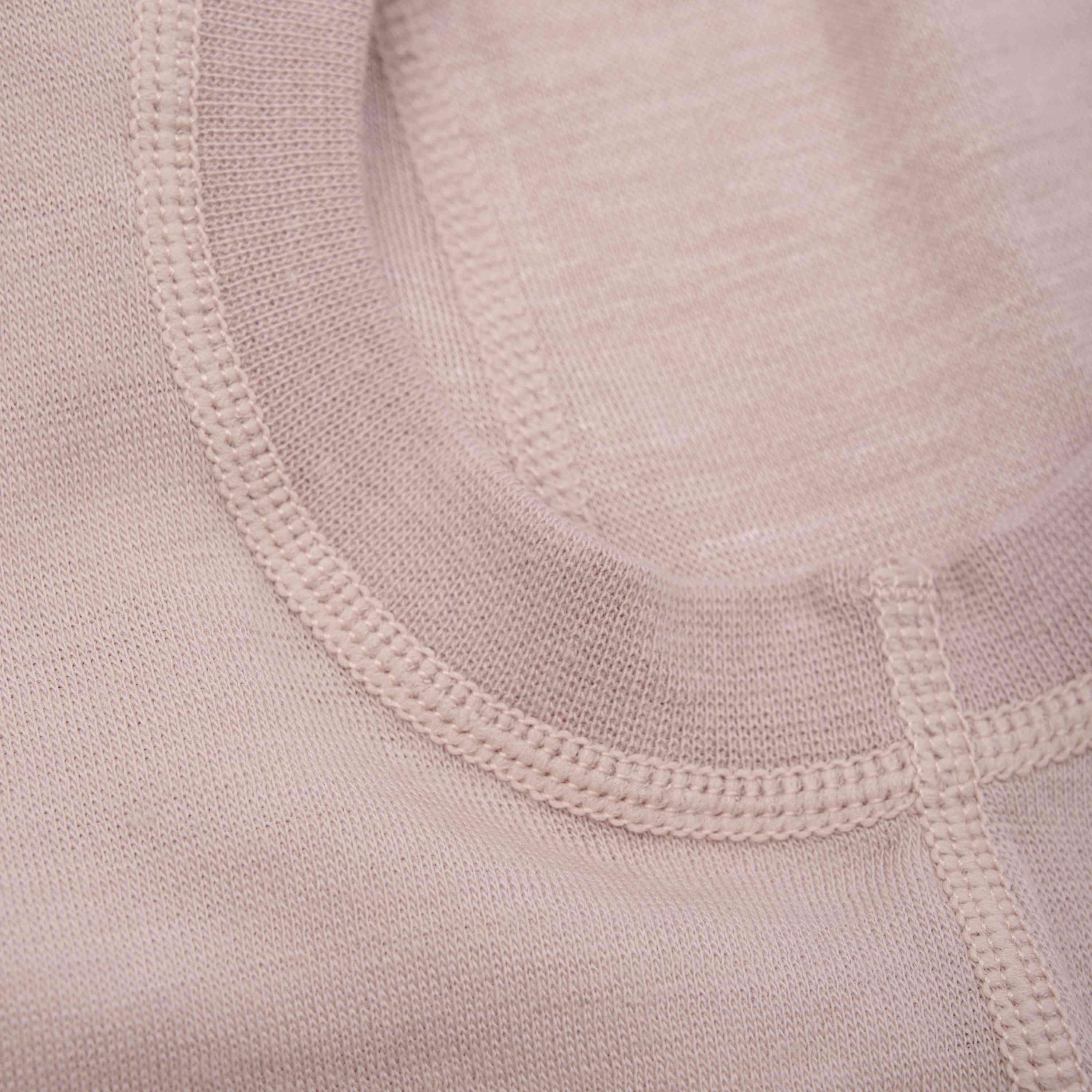 Nahaufnahme der hellrosa CeLaVi – Balaclava aus 100 % Merinowolle mit detaillierten Nähten am Halsausschnitt und an den Säumen. Der Stoff wirkt weich und fein gewebt, was die Handwerkskunst der Näharbeit unterstreicht. Dieses Stück ist außerdem nach OEKO-TEX® STANDARD 100 zertifiziert, was für zusätzliche Sicherheit sorgt.