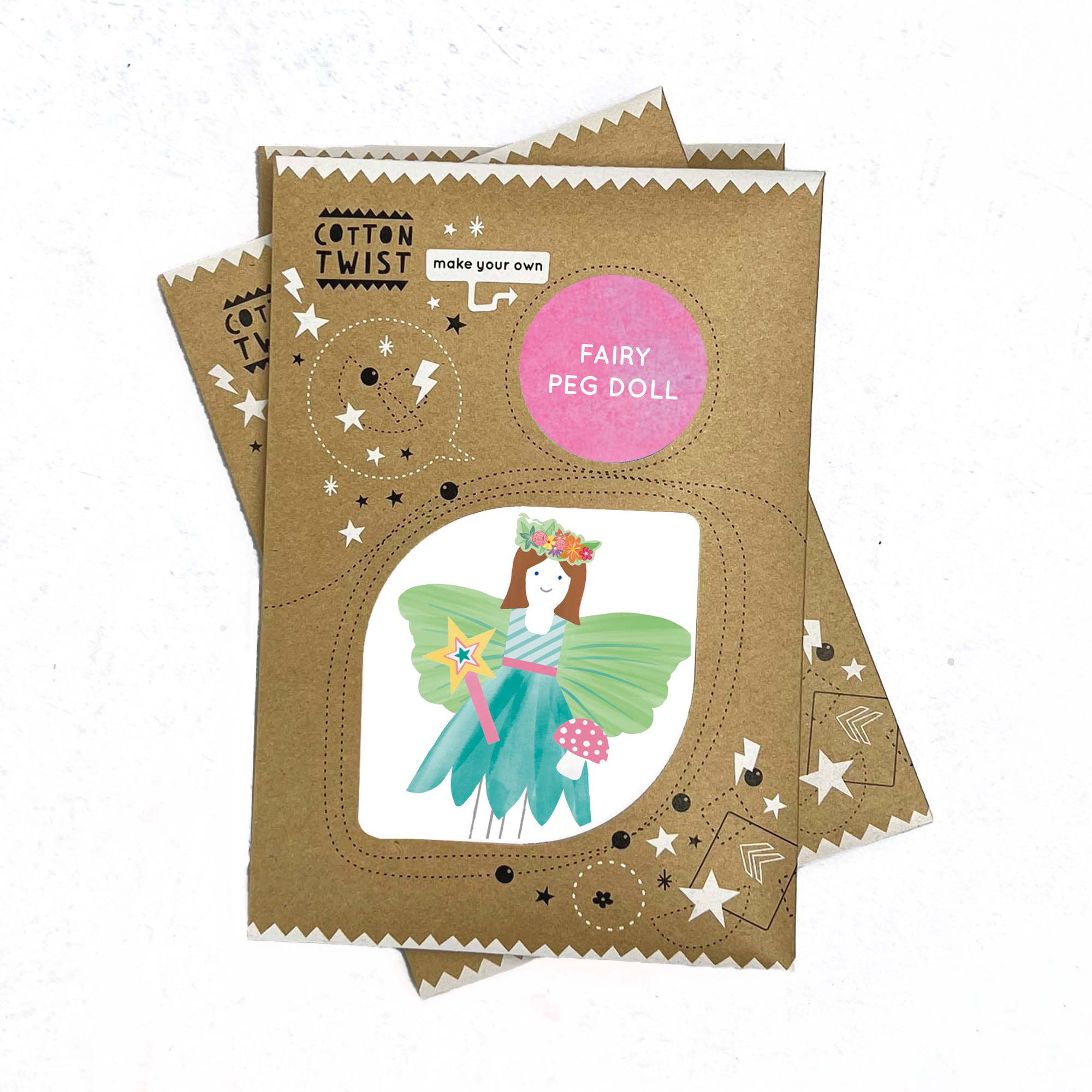 Eine Produktverpackung, die ein „Cotton Twist - DIY Fairy Peg-Puppe“-Set zeigt. Die Kartonverpackung, die mit skurrilen Sternen-, Mond- und Musiknotenkritzeleien gestaltet ist, zeigt eine Illustration einer Fee mit grünen Flügeln, einer Blumenkrone und einem Zauberstab. Der Markenname „Cotton Twist“ ist enthalten. Hergestellt aus umweltfreundlichen Materialien, um Feinmotorik als Kinder-Produkt zu fördern.