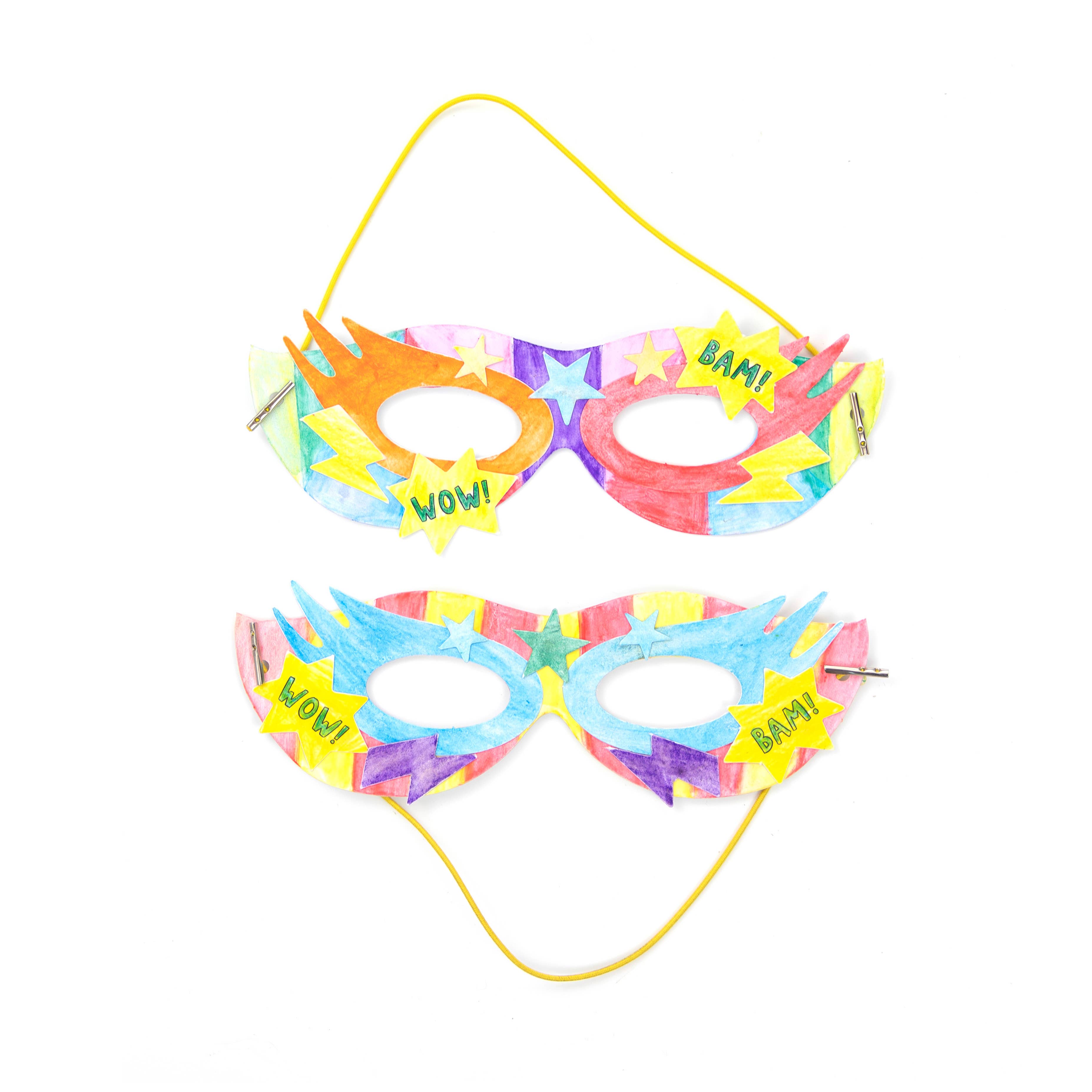 Zwei farbenfrohe DIY-Superheldenmasken von Cotton Twist, hergestellt aus umweltfreundlichen Materialien. Jede Maske hat Aussparungen für die Augen und ein Gummiband für mehr Tragekomfort. Die obere Maske ist mit orangefarbenen, blauen und gelben Mustern verziert und zeigt die Worte „WOW!“ und „BAM!“. Die untere Maske hat ein ähnliches Design in Blau-, Lila- und Gelbtönen. Perfekt für Kinder!