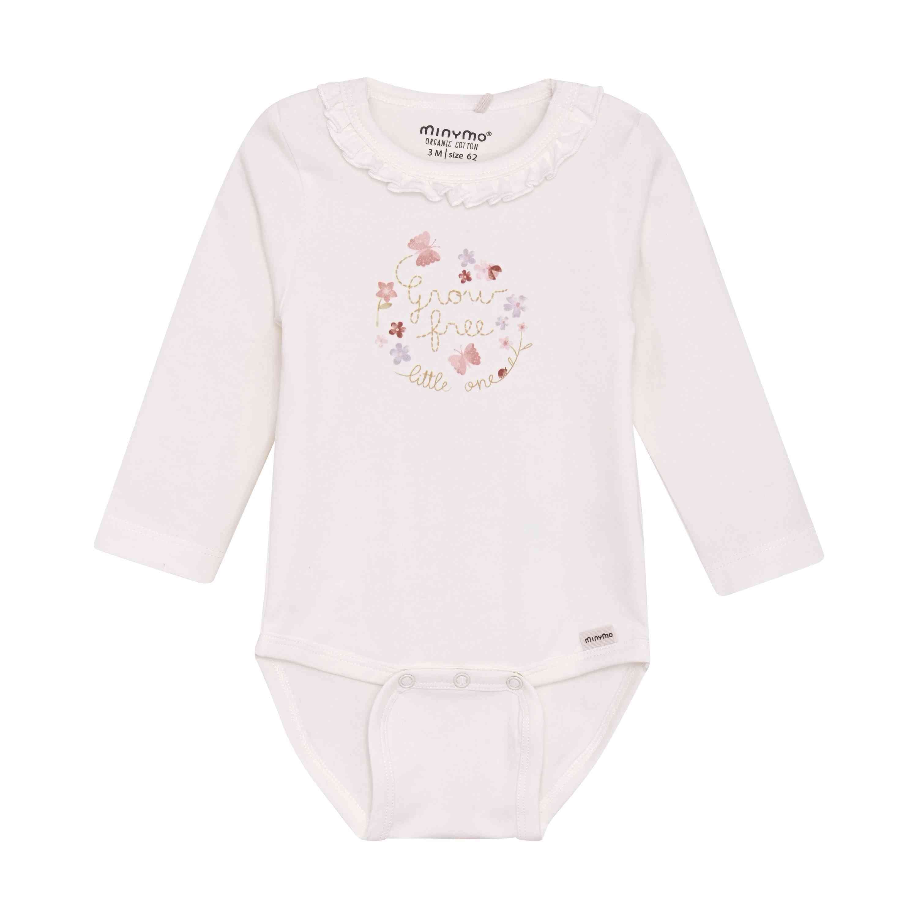 Ein weißer langärmliger Minymo-Body mit Rüschenausschnitt. Die Vorderseite zeigt ein Blumenmuster mit dem Text „grow free little one“ in sanften Pastellfarben. An der Unterseite befinden sich Druckknöpfe zum einfachen Befestigen. Das Markenlabel „Minymo“ ist in der Nähe des Kragens sichtbar.