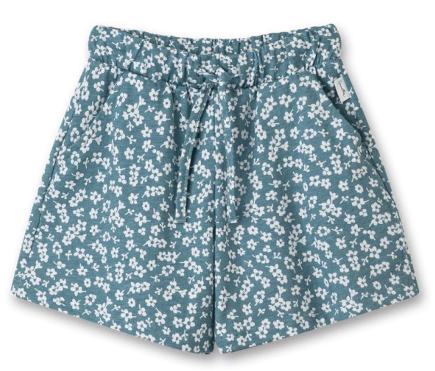 Die Sanetta - Hose von Sanetta ist eine Shorts mit türkisem Hintergrund und weißem Blumenmuster. Sie hat einen elastischen Bund mit Kordelzug zur Anpassung, Vordertaschen und einen Allover-Druck auf Bio-Baumwollstoff für eine entspannte Passform.