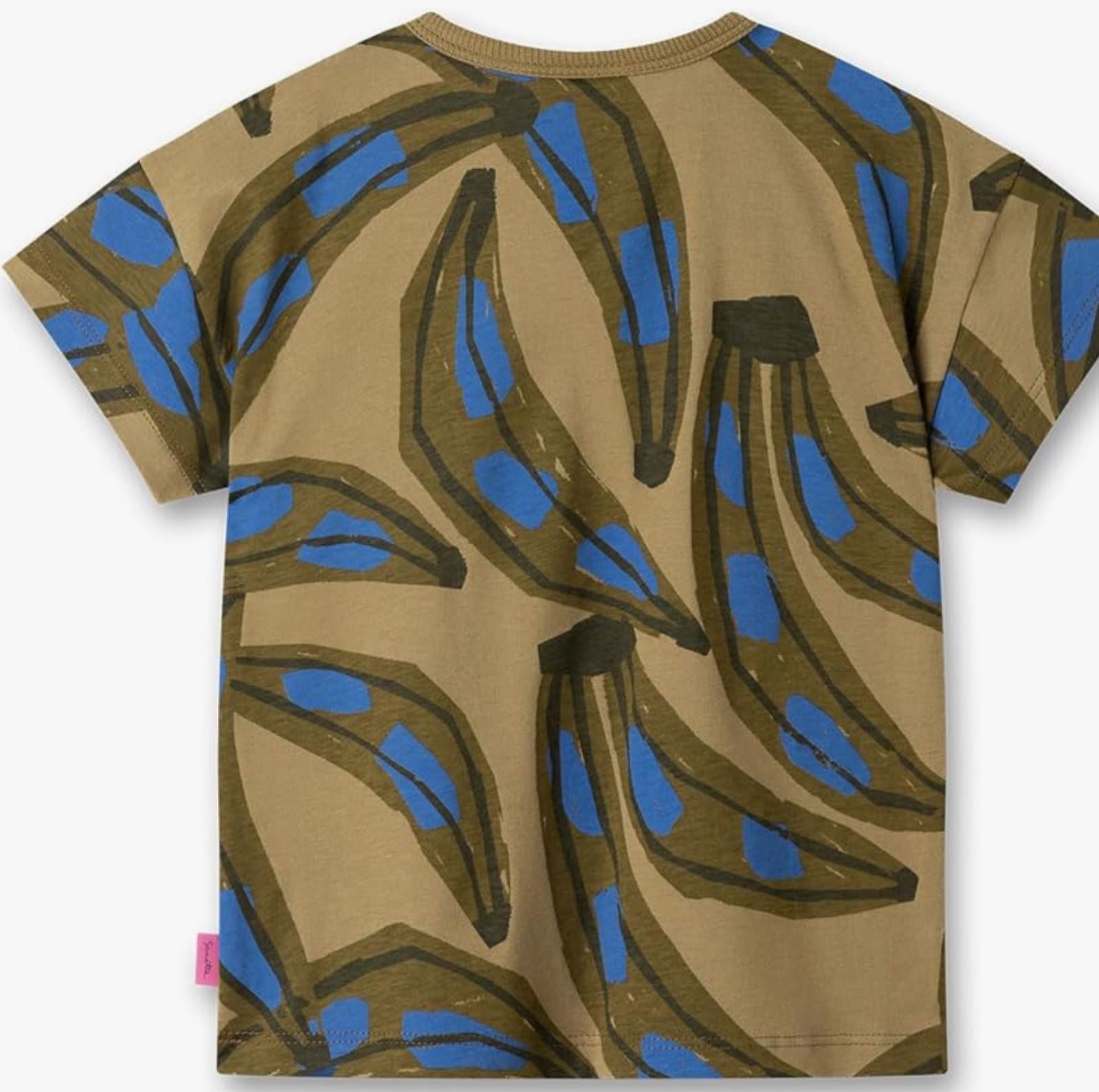 Das Sanetta - T-Shirt von Sanetta ist ein braunes Kurzarmshirt mit einem abstrakten Bananendesign in Dunkelbraun mit blauen Akzenten. Die Bananen sind in einem sich wiederholenden Muster durch den gesamten Stoff aus Bio-Baumwolle illustriert. Ein kleines rosa Etikett, das GOTS-zertifiziertes Material kennzeichnet, ist an der linken Seitennaht nahe dem unteren Saum sichtbar.