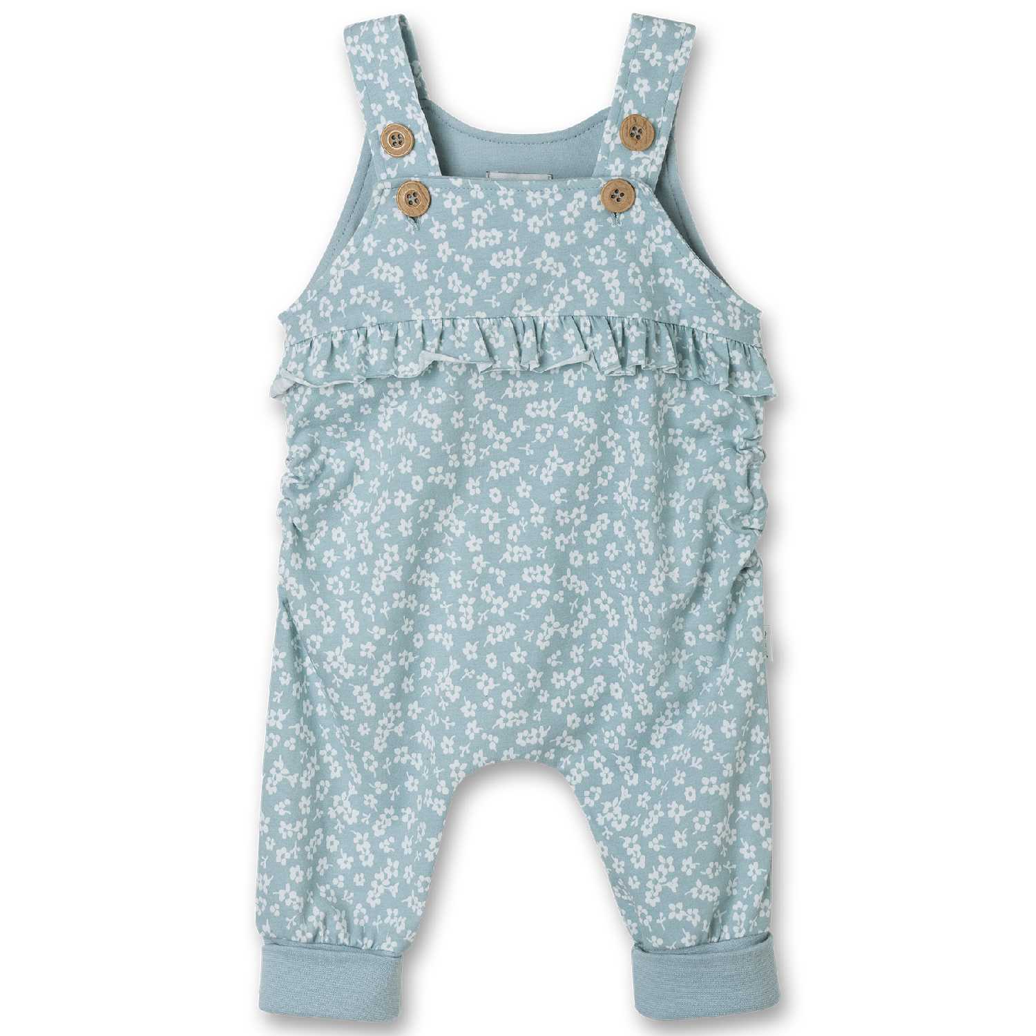 Blauer Baby-Overall mit weißem Blumendruck, Rüschen über der Brust, verstellbaren Schultergurten mit Holzknöpfen und elastischen Bündchen an den Knöcheln. Perfekte Ergänzung zu einem Sanetta - Strampler/Overall von Sanetta für ein verspieltes und bezauberndes Outfit.