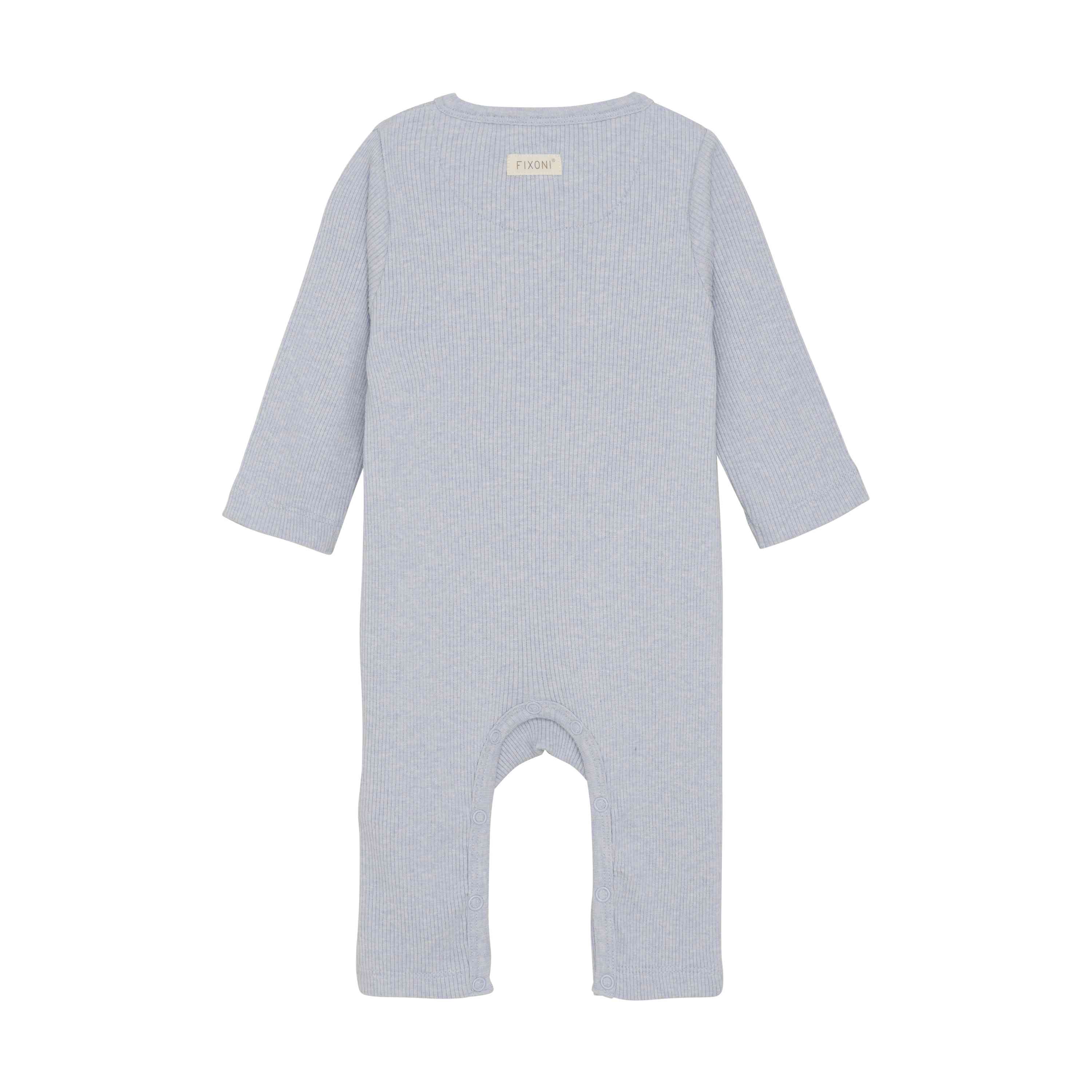 Der Fixoni - Strampler von Fixoni ist ein hellblauer, langärmliger Baby-Strampler aus geripptem TENCEL™-Stoff. Er hat ein kleines Etikett im oberen Rückenbereich und reicht bis zu den Knöcheln. Das Design ist schlicht und funktional und kommt ohne sichtbare Verschlüsse oder Verzierungen aus.