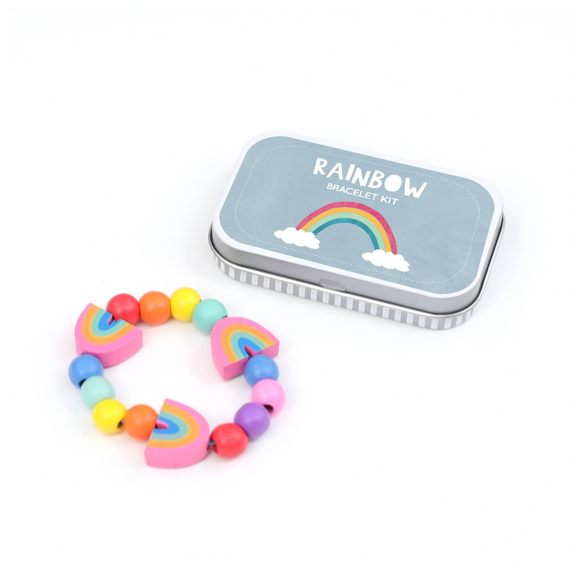 Ein farbenfrohes DIY-Regenbogenarmband aus plastikfreien Perlen mit Regenbogenmotiven wird neben einem kleinen Blechbehälter mit der Aufschrift „Cotton Twist – DIY Regenbogen-Armband“ präsentiert. Die Perlen in runder und regenbogenartiger Form sind in einer lebhaften Farbpalette angeordnet. Der Behälter eignet sich ideal als Gastgeschenk und hat einen grauen Deckel mit einer Regenbogenillustration.