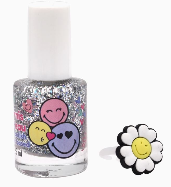 Eine Flasche Take Care - Nagellack auf Wasserbasis für Kinder, geschmückt mit lächelnden, bunten Emoji-Gesichtern. Daneben steht ein Ring mit einer weißen Gänseblümchenblüte und einem gelben, lächelnden Gesicht in der Mitte. Beide Artikel sind perfekt, um Ihrer Haarschmuck-Kollektion einen Hauch von festlichem Charme zu verleihen. Sie sind auf einem schlichten weißen Hintergrund platziert.