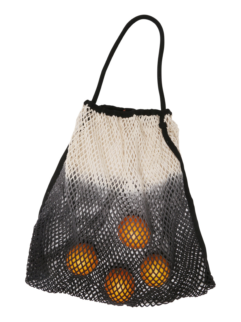 Eine schwarz-weiße Netztasche mit einem Farbverlauf von Schwarz unten nach Weiß oben zeigt fünf Orangen, die deutlich an einem schwarzen Griff hängen. Diese stilvolle Tasche, der Mara Mea mara mea - Kinderwagen Netz - schwarzer Bär, ist in jedem Kinderartikelgeschäft zu finden und bietet sowohl Funktionalität als auch optische Attraktivität.